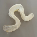 Detail view of wavy cream marble hair claw clip with a secure golden metal spring - 11cm / Champagne Flow Pattern