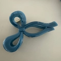 Close-up of a large dark teal glossy bow hair claw clip with golden metal spring - Deep Lake Blue