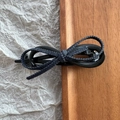 Detail of a chic leopard print leather bow hair clip on a minimalist wooden background - Black Denim Bow