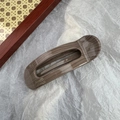 Makroaufnahme einer quadratischen Haarspange im Leopardenmuster mit goldenem Goldlogo - Ovale Klammer / Kaffee Holz Oval