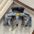 Makro-Detail der Haarklammer mit Marmor-Muster und gravierter goldener Metallplatte - Grau Mit Metallschild