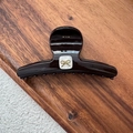 Detail view of a large dark brown hair claw clip with a white shell and golden bow design - Reddish Brown Bow