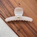 Detail of high-quality acetate hair claw clip featuring a golden metal bow and wood texture - Off White Bow