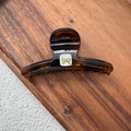Detail of amber tortoiseshell hair claw with white shell insert and golden metal bow - Tortoiseshell Bow