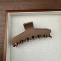 Vue détaillée d'une grande pince à cheveux marron mat avec design ondulé sur plateau - Marron Droit (11cm)