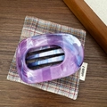 Vue détaillée de la pince à cheveux en acétate marbré violet avec motif ovale et griffes - Violet
