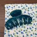 Macro view of a deep green 11cm shark hair clip with a smooth resin finish and teeth design - Lake Blue