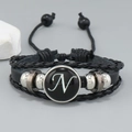 Close-up of multilayer braided leather bracelet with silver beads and letter N glass charm - Letter N