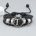 Detail of multi-layer leather bracelet featuring letter T charm and woven rope texture - Letter T