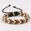 Detailopname van de verstelbare knoop en driekleurig vlechtpatroon op de handgemaakte armband - Wit Groen Oranje