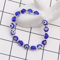 Retro blue evil eye beaded bracelet with silver spacers on white ceramic hand display - Hamsa Hand Evil Eye Beaded / Blue