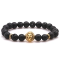 Close-up of black volcanic lava stone beads with a golden lion head and metal spacers - Lava Stone