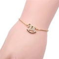 Detalle de pulsera dorada ajustable con dije de caballo balancín pavimentado con circonitas - Oro Circonita Negra