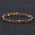 Bracelet en perles de pierre de lune marron avec effet halo bleu sur fond noir - Marron