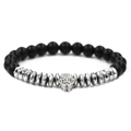 Makroaufnahme eines matt schwarzen Lavastein-Perlenarmbands mit silbernem Totenkopf - Silbernes Totenkopf Armband