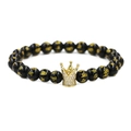 Pulsera de corona en piedra volcánica negra con cuentas de mantra doradas y circonitas finas - Corona Grande Oro