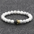 Macro detail of white turquoise beads with a gold crown charm and black lava stone - White Turquoise Small Crown