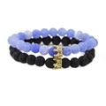Blaues Perlenarmband und schwarzes Lavastein-Kronen-Set für Paare auf weißem Hintergrund - Armbandset / Lavastein Gold Krone Set