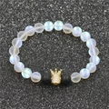 Macro détaillée d'un bracelet en perles de lune, pierre de lave et breloque couronne dorée - Grande Couronne Pierre de Lune Pierre de Lave