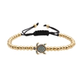 Woven bracelet with golden beads and a turtle charm featuring blue zircon stones - Gold