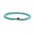 Detail van turquoise kralenarmband met een metalen yin yang bedel op een witte achtergrond - Turkoois