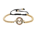 Pulsera tejida ajustable con cuentas doradas y letra M con circonitas de colores - M