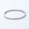 Detalle de brazalete de acero inoxidable pulido plateado con cierre de bisagra y acabado liso - Color Acero