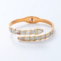 Details eines goldenen Schlangen-Federarmbands mit Muscheleinlagen und Zirkon-Steinen - Roségold