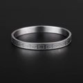 Polished silver titanium steel ring with retro Greek key pattern on black background - Steel