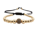 Makroaufnahme der 10mm Mikro-Zirkonia Goldkugel an einem geflochtenen Armband - Gold Schwarzer Zirkonia