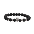 Vue macro des perles de lave noire avec un charm crâne en argent détaillé sur un bracelet - Crâne