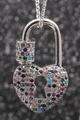 Silberne Herzschloss-Halskette mit bunten Zirkoniasteinen auf schwarzem Bokeh-Hintergrund - Platin Herzschloss
