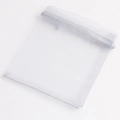 Detalle de una bolsa de regalo de organza gris claro con cintas de raso suaves - 9x12cm / Blanco Transparente