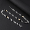 Macro view of 8mm stainless steel Figaro chain with golden beads and lobster clasp - 8mm Wide / Gold and Silver Tone / 55cm Length
