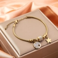 Bracciale quadrifoglio dorato con ciondoli stella e diamante su sfondo di seta - Stella e Disco Rotondo Pavé / Oro