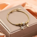 Detail of 18K gold snake chain bracelet with sparkling crystal star charms on satin - Star Pendant Style