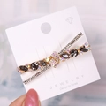 Fermaglio per capelli a X in oro con cristalli grigio scuro e strass iridescenti - K9 / Grigio