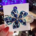 Elegante pinza per capelli a fiore dorato con strass blu e verde acqua su cartoncino - Blu