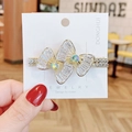 Fermaglio per capelli a farfalla dorato con strass e pietre iridescenti su cartoncino - Stile Doppio Fiocco