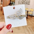 Eleganter goldener Schmetterlings-Haarclip mit funkelnden Zirkonen auf einer Karte - Fischschwanz Stil