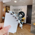 Elegante pinza per capelli nera con perle, strass e corona d'argento tenuta in mano - Nero Perla Corona