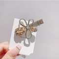 Detailed close-up of champagne crystal bow hair clip with fine rhinestone inlay - Champagne