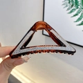 Bernsteinfarbene hohle Dreieck-Haarklammer mit glänzenden Strasssteinen in der Hand - Dreieck Kaffee 9CM