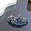 Detail einer eleganten Goldlegierung-Haarklammer mit blauen Strasssteinen und Blumenmuster - Dunkelblau Blumen Federclip
