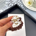Elegante bruine scrunchie met parels en strasstenen getoond in een lifestyle-scène - Bloem Parel Koffie