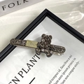 Detailaufnahme der Bären-Haarspange mit grauen Strasssteinen und goldenem Schild - Bär-Stil Entenschnabel-Clip