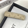 Elegante pinza dorada con perlas crema en capas y pedrería brillante en el borde - Blanco Roto