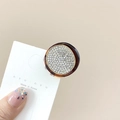 Macro detail of a round hair claw clip with tortoise shell base and sparkling rhinestones - Round Coffee White Stone