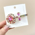 Detail einer bunten Strass-Haarklammer mit rosa Edelstein auf einer goldenen Basis - Lutscher Mehrfarbiger Clip / Bunt