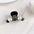 Close-up of mini hair claw with elegant pearls and smoky grey rhinestones on black resin - Two Flowers with Rhinestones